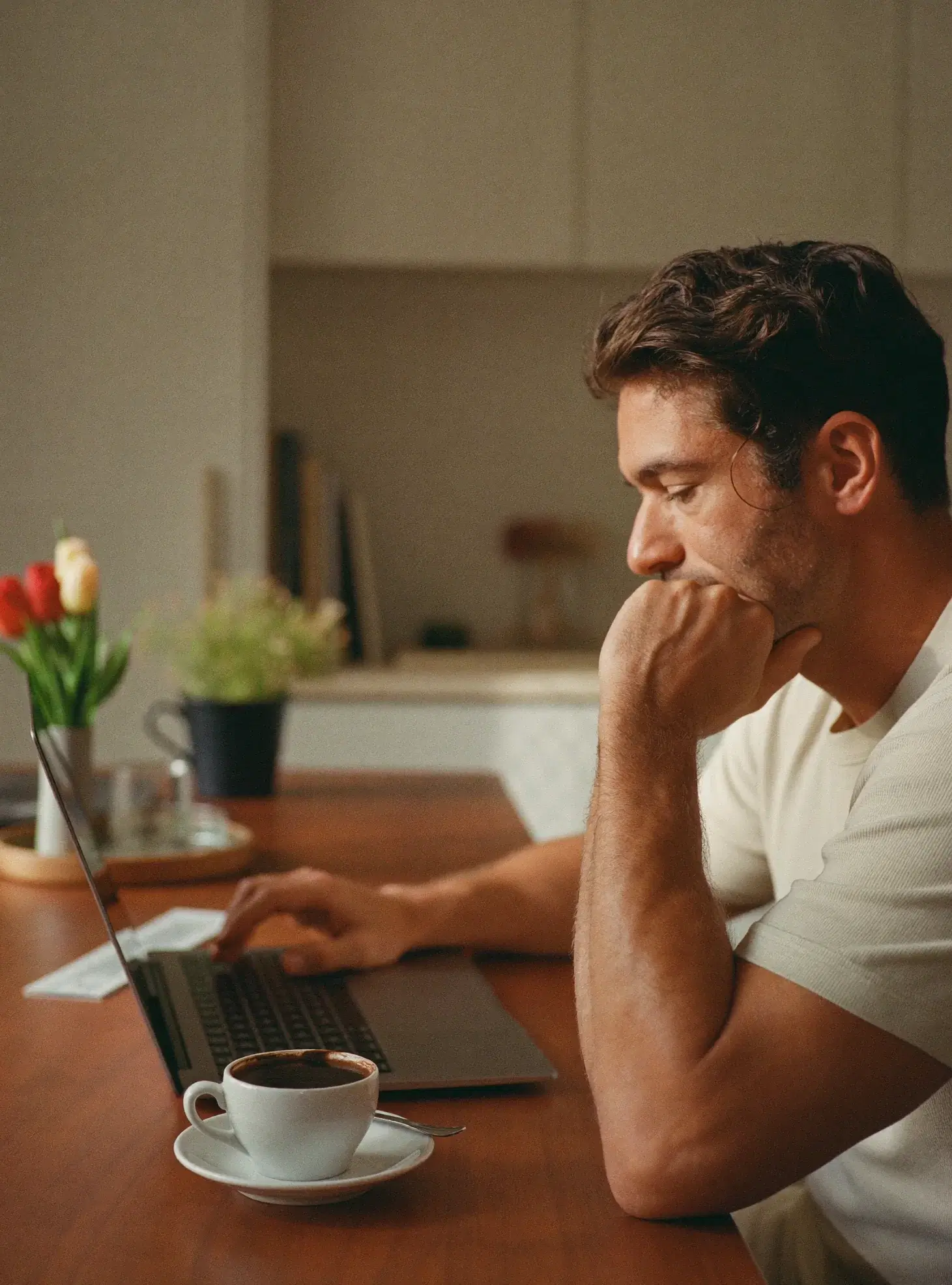 Man choosing a panel on his laptop at the kitchen table