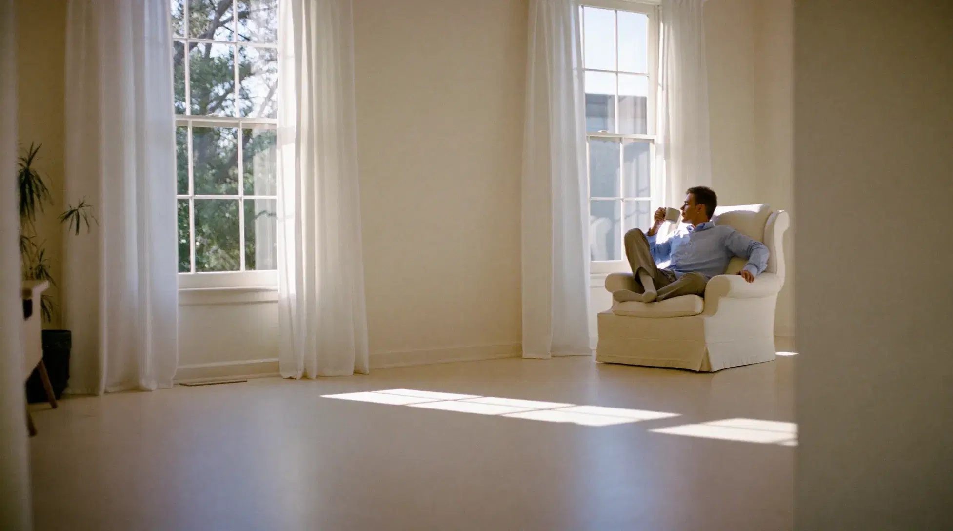 Man with a morning coffee in an armchair in a bright, open room